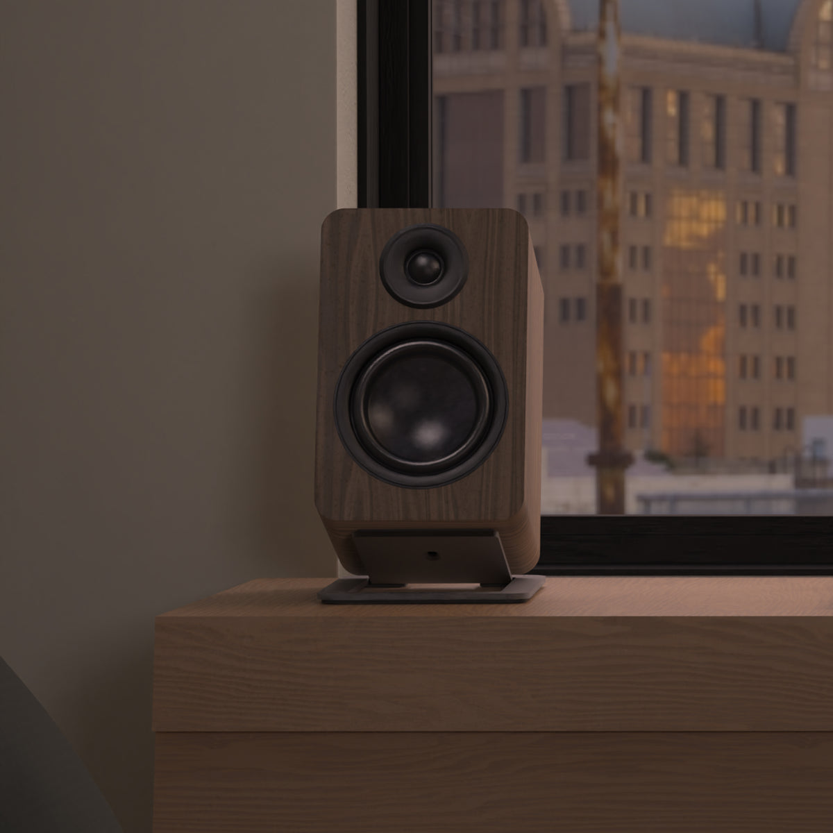 A wooden speaker, sitting on a wooden surface in front of a window with a city view.