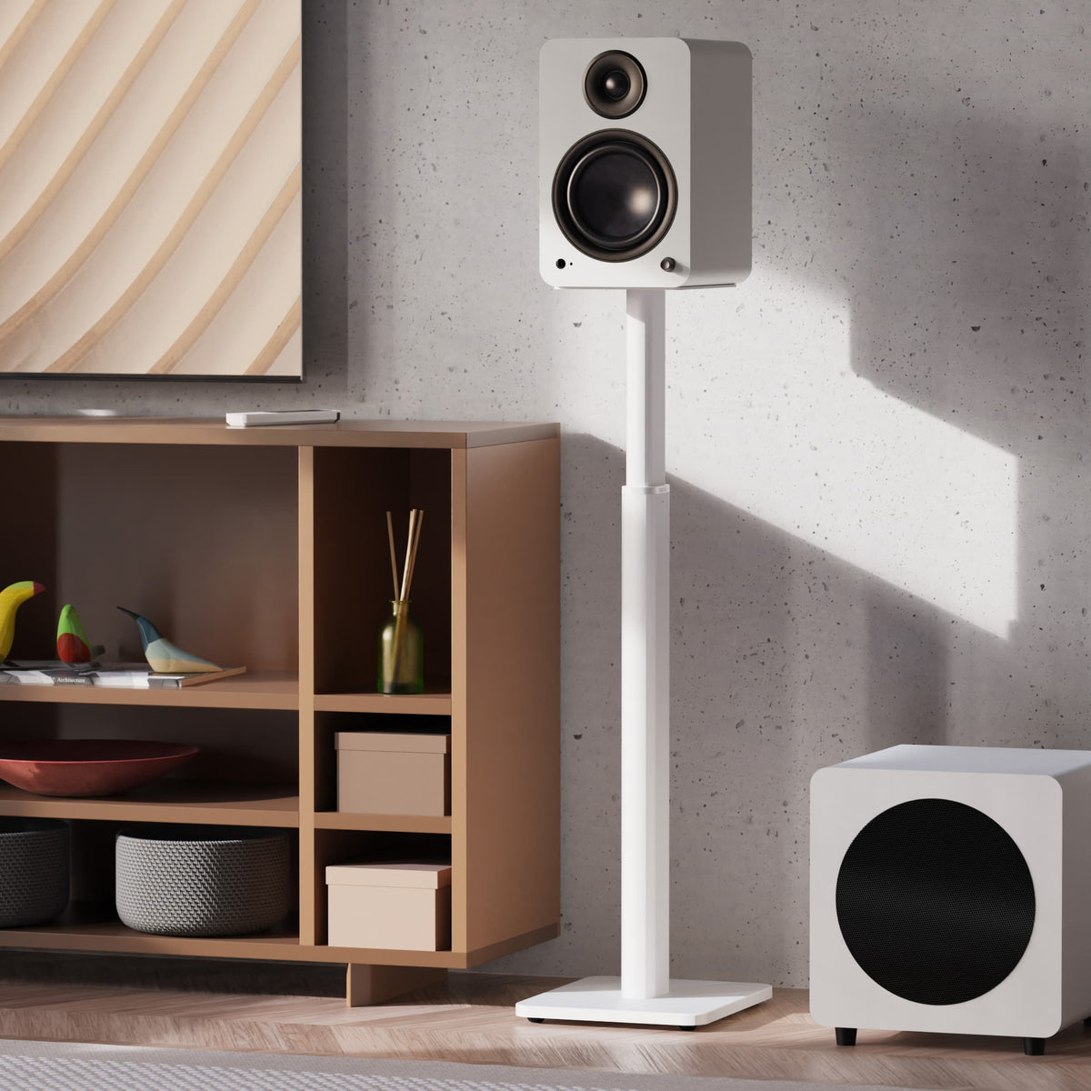 A white Kanto Yu6 speaker and matching white subwoofer, shown in a modern living room setting with a wooden cabinet, textured wall, and decorative objects.